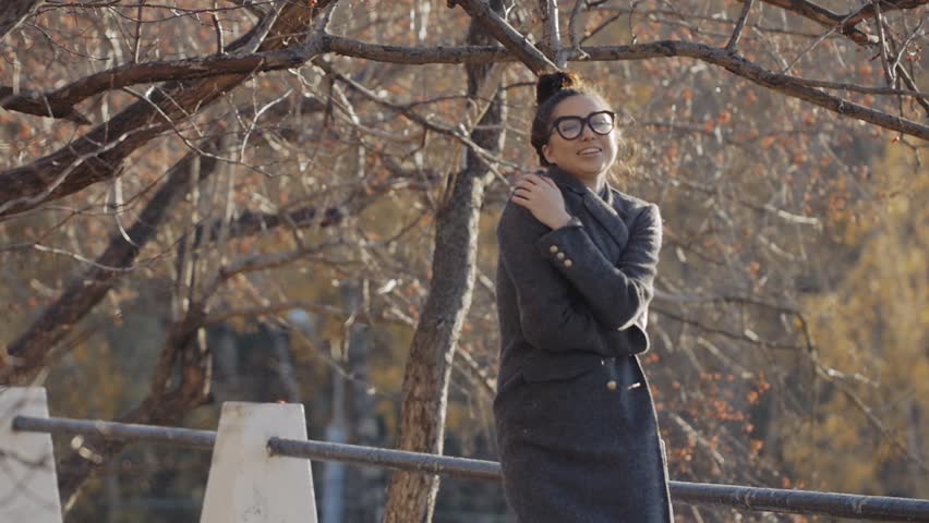 Urban Model Woman in Fashion coat and glasses Having Fun. Glamour Sexy Hipster Girl, Trendy Hairstyle in Autumm Streets Joking. Student Fall Fashion.