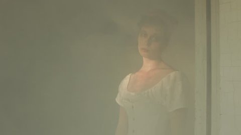 VIRGINIA - SUMMER 2016 - Reenactment, Recreation -- Ghostly, undead woman in smoky room in haunted house.  Paranormal, poltergeist.  Mystery woman with pale pallor, 19th century clothing in dank room