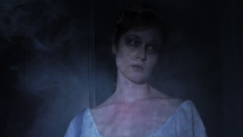 VIRGINIA - SUMMER 2016 - Reenactment, Recreation -- Ghostly, undead woman in smoky room in haunted house.  Paranormal, poltergeist.  Mystery woman with pale pallor, 19th century clothing in dank room
