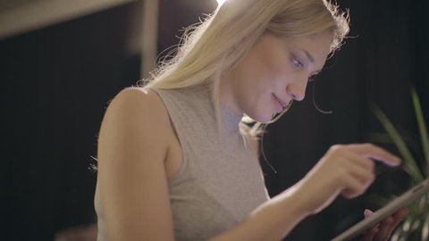 Two different panning shot of a caucasian woman using tablet computer, 4K
