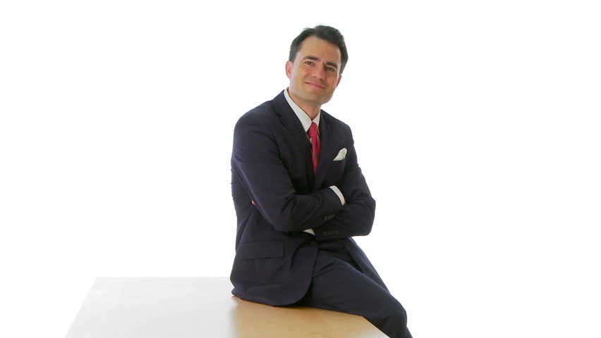 Businessman sitting on table smiling at camera