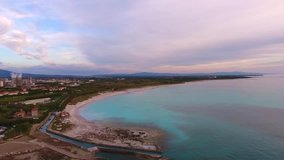 Aerial shot,  incredibly beautiful calm sea in the sunset light with lots of clouds,  white beach created because of huge water pollution  with  very calm sea, filmed with drone