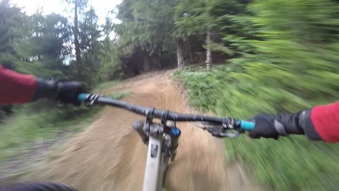 Mtb Mountain biker crash with downhill bike. Cyclist rides a single trail with berms, hits a tree with his handlebars and crashes. 