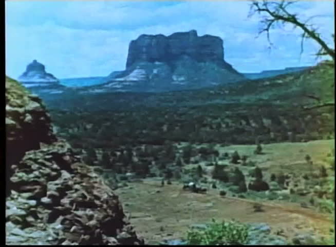 Wide shot of lookout watching stagecoach crossing prairie