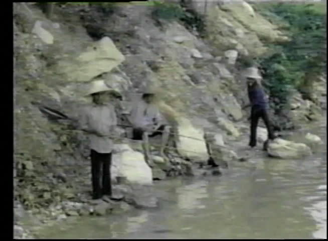 Asian fishermen casting a net in river