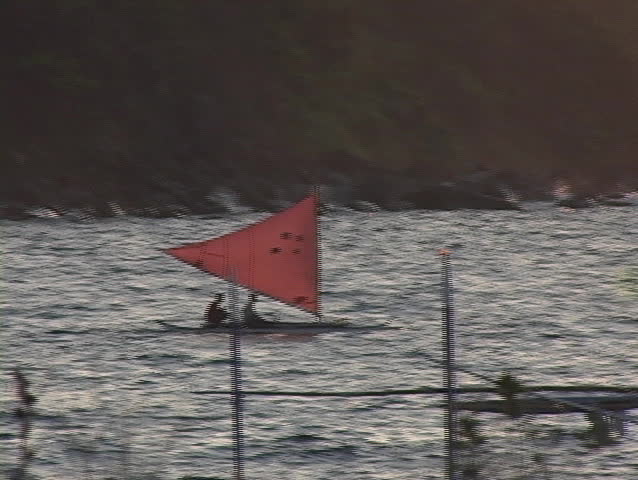 A native handmade sail boat leaves the beach