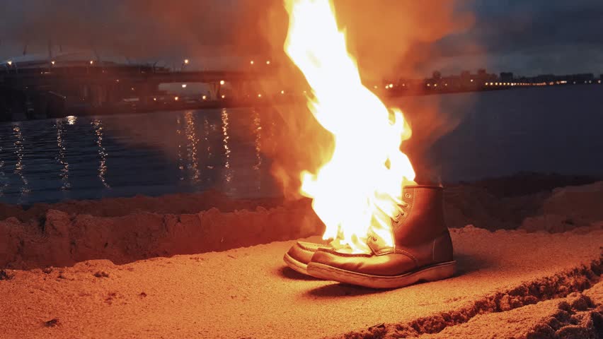 Burning Boots On the Sand Stock Footage 