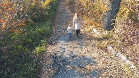 Mother with baby walking outdoor. Top view, dron helicopter. Autumn