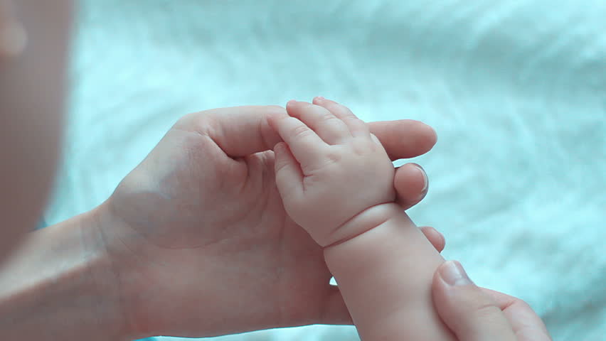 Parent holding babys hand