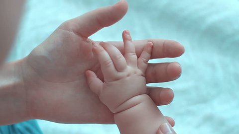 Parent holding babys hand