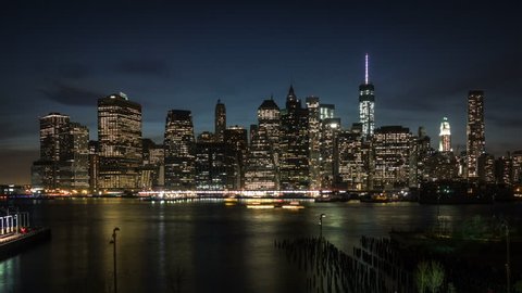 View of Manhattan skyline from Brooklyn waterfront. From day to night. Skyscrapers lights turning on while the night is coming. Time lapse.