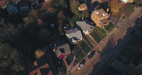 An aerial view above a small Western Pennsylvania town and residential neighborhood on an Autumn evening. Pittsburgh suburb.	 	