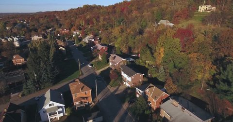 An aerial view looking down on a small Western Pennsylvania town and residential neighborhood on an Autumn evening. Pittsburgh suburb.	 	