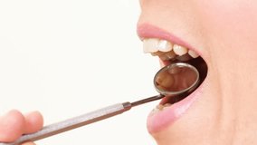 Woman teeth with a dental mirror.
