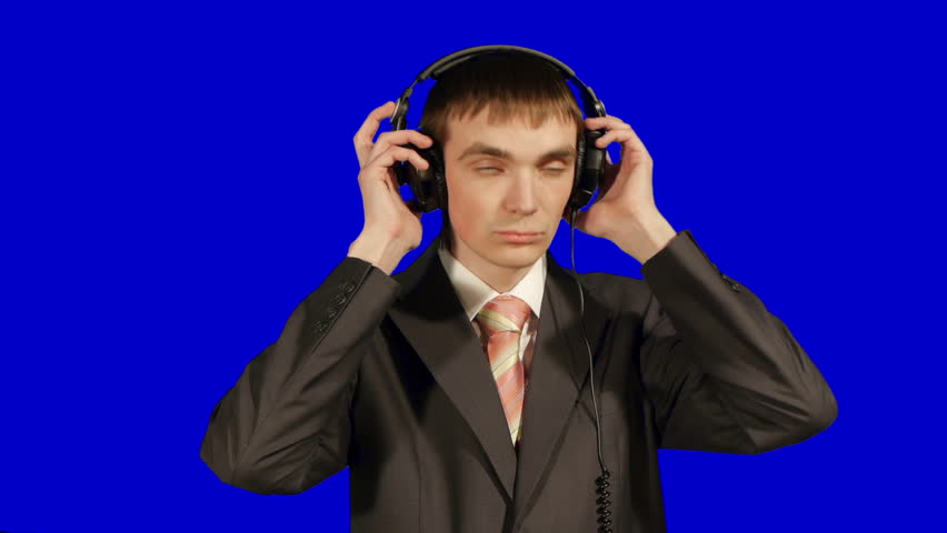 young businessman listen music in headphones, isolated over blue background