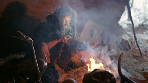 Prehistoric caveman using laptop