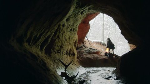Prehistoric caveman goes to his cave
