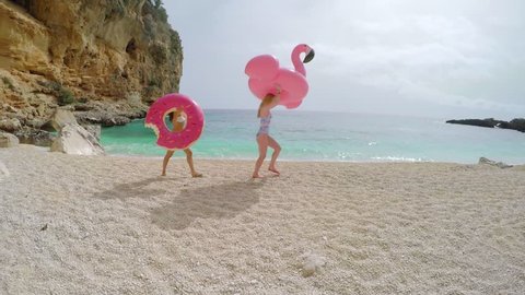 Beautiful girl Friends with inflatable flamingo donut on paradise beach vacation having fun on summer travel vacation