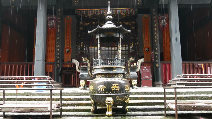 Temple entrance with shrine in which offerings to the spirits are burnt with rain falling, Qingcheng mountain Chengdu, place of founding of Chinese Taoism