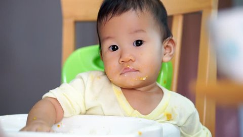 9 months old Asian baby try talking while eating food