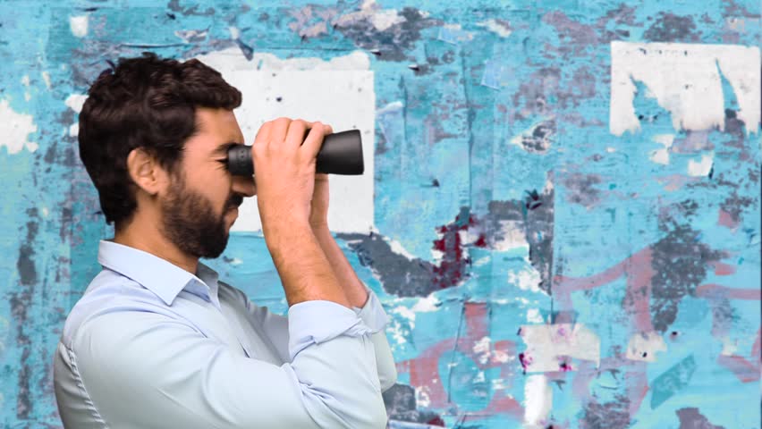 young man with binoculars on grunge wall