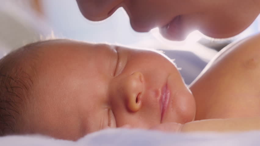 Mom stroking and kissing newborn baby | Shutterstock HD Video #21043582