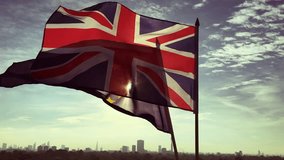 European Union and British Union Jack flag flying together in front of a sunrise skyline of London, England