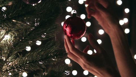 Hand woman decorating on Christmas tree with Christmas glow lights. Arkivvideo
