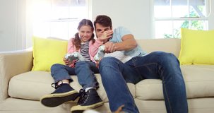 Father and daughter playing video game in the living room at home 4k