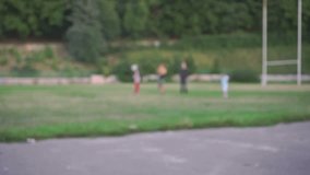 Children playing with ball outdoors at sunny day. Blur defocused slow motion video