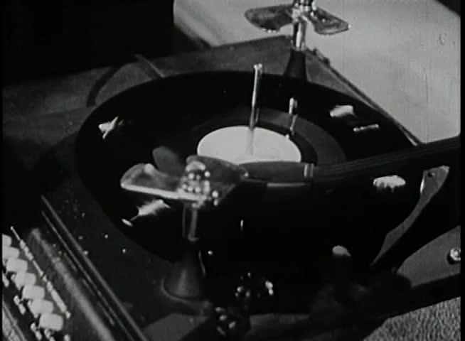 Close-up of man taking needle off record on vintage turntable