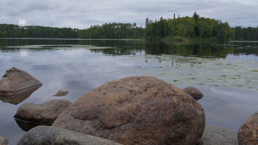 Canadian lake in summer - Camera slider ahead near stones