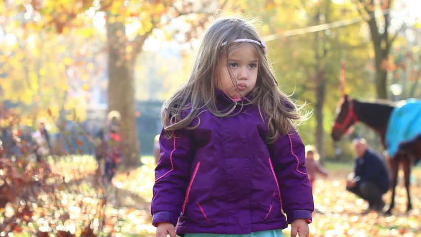 Portrait of little girl in autumn park.