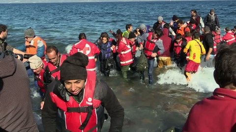 LESVOS, GREECE - NOV 2, 2015: Refugees leave rubber dinghy near the shore.