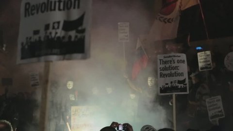 LONDON, UK - NOVEMBER 5, 2016: Protesters and Anonymous supporters wearing Guy Fawkes masks lit up Trafalgar Square in London with flares as part of the annual anti-capitalist Million Mask March.
