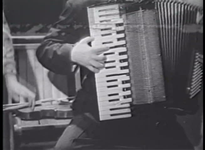 Medium shot of accordion player and band leader