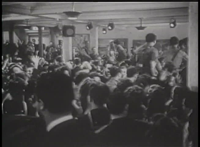 Wide shot of World War II servicemen celebrating