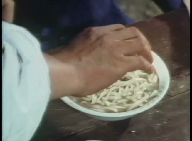 Close-up of person mixing noodles in soup