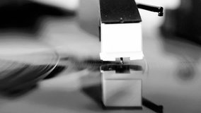 Vinyl record spinning on a turntable, focus on needle - in black and white