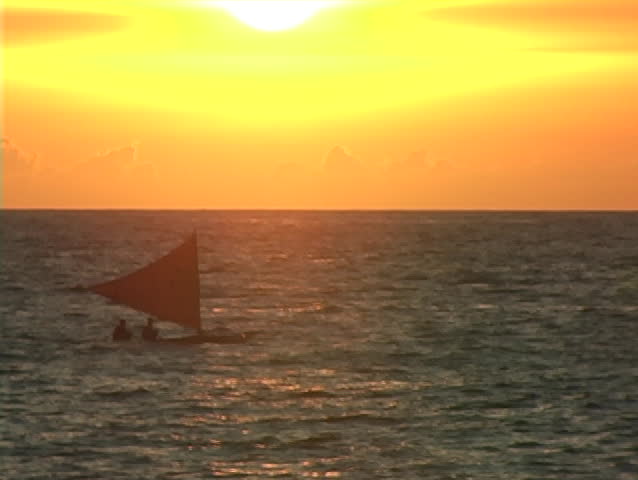 Hand made native sailboat crosses field of view during sunset #2