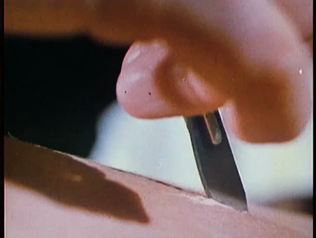 Close-up of hand with knife making incision in skin
