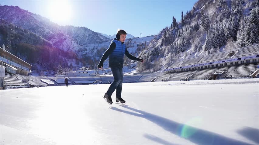 Happy boy ice skating at rink outdoor