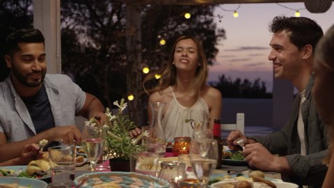 Friends laughing at a dinner party on a roof terrace, Ibiza, shot on R3D