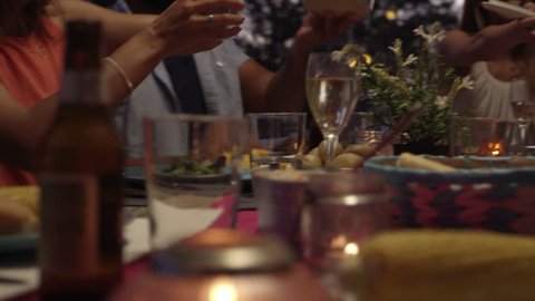 Friends passing food at dinner on a roof terrace, close up, shot on R3D