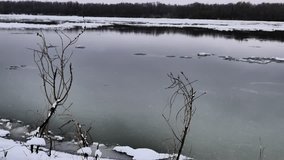 Ice and snow lumps on the Irtysh River. Grey autumn landscape.  Sky reflections in the water.  Increased contrast video images. November 2016 Omsk Russia