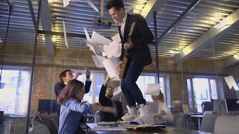 Happy successful business people in office having fun throwing documents