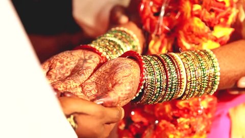 Indian wedding ritual / Bride and groom joining hands during an Indian wedding ritual
