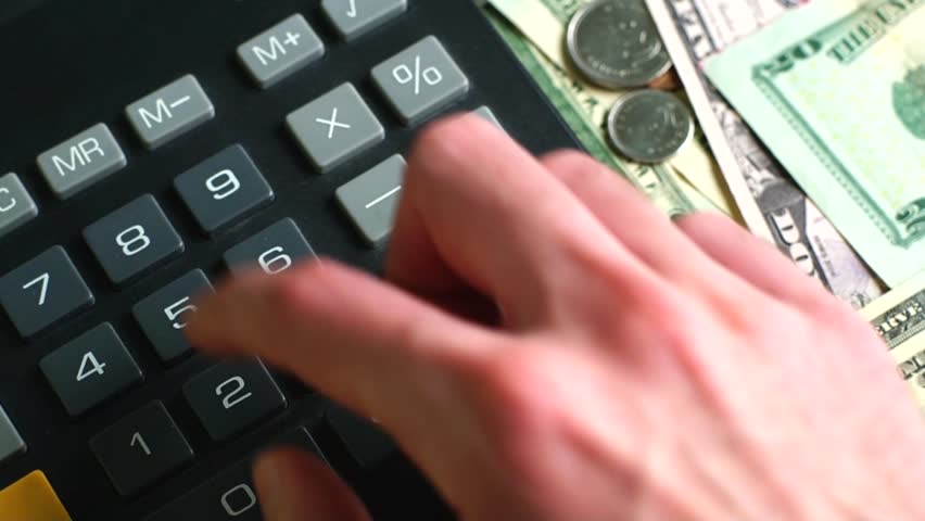 Man calculating money ( taxes) with his calculator.