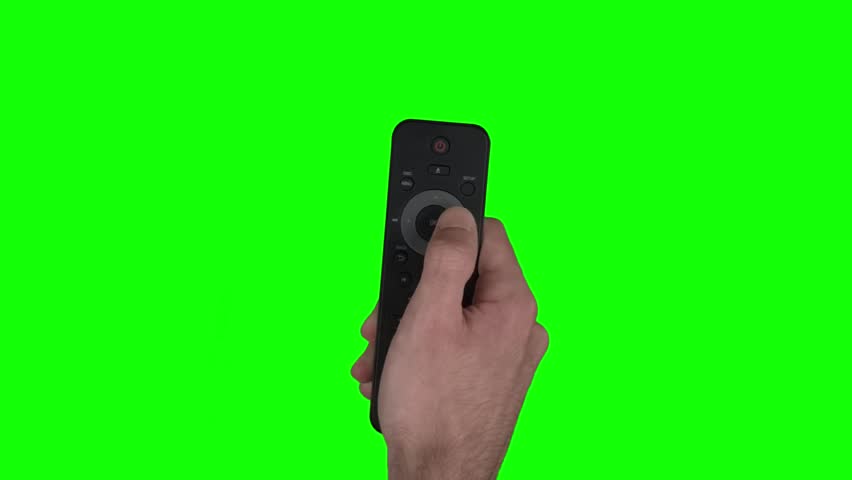 Close up shot of a hand holding a telivision remote in front of a green screen