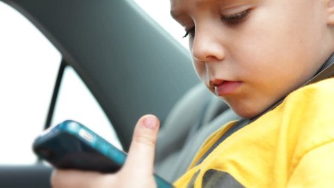 Boy using cell phone in car